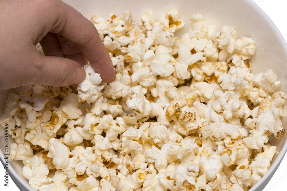 Popcorn viewed from above on blue background. Woman eating popcorn. Human hand. Top view Popcorn viewed from above on blue background. Woman eating popcorn. Human hand. Top view