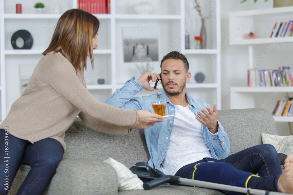 Fototapeta premium boyfriend on the phone while girlfriend offers tea