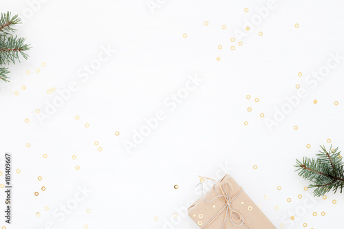 Christmas gift box on white. New Year card with fir, present and gold confetti. Winter holidays, Boxing Day concept. Flat lay, minimal.