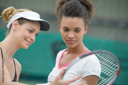 female tennis players checking racquet