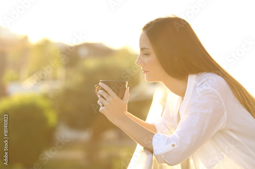 Fotografia Sad pensive woman in a balcony at sunset