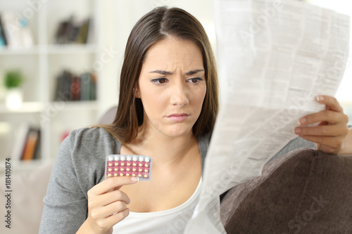 Tableau sur toile Worried woman reading contraceptive pills leaflet
