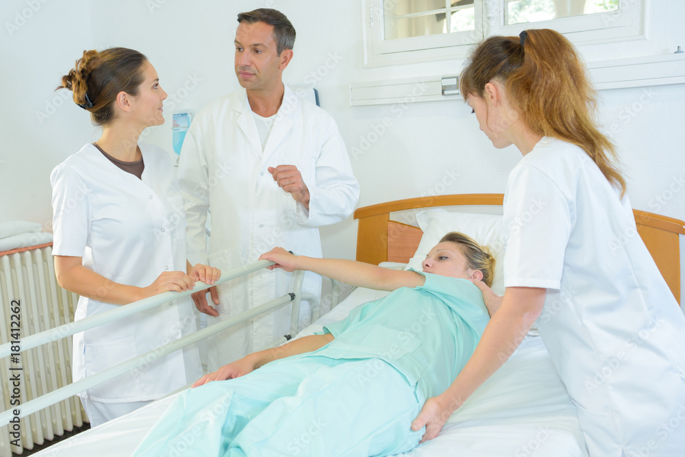 nurse rolling patient over in hospital bed nurse rolling patient over in hospital bed