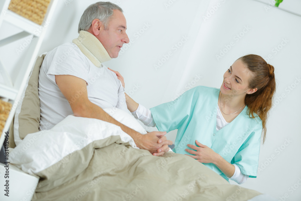 old man in bed with nurse touching his arm old man in bed with nurse touching his arm