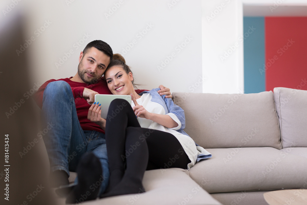 couple relaxing at  home with tablet computers