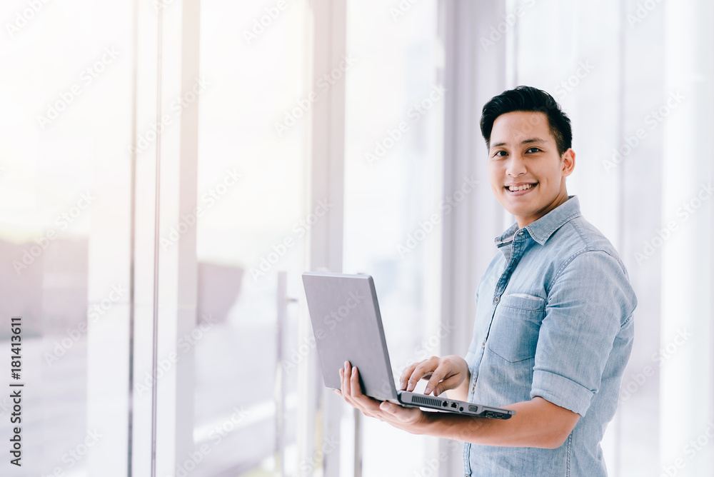 Happy smile Asian man using laptop with positive feeling in office. business success concept. Happy smile Asian man using laptop with positive feeling in office. business success concept.
