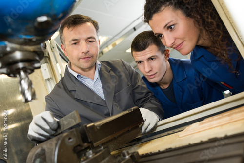 Students watching instructor using bench drill