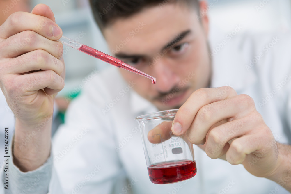 handsome male chemist setting up a blood test handsome male chemist setting up a blood test