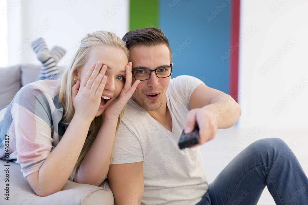 Young couple on the sofa watching television Young couple on the sofa watching television