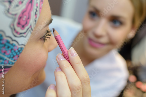 Billede på lærred Beautician applying makeup to female client