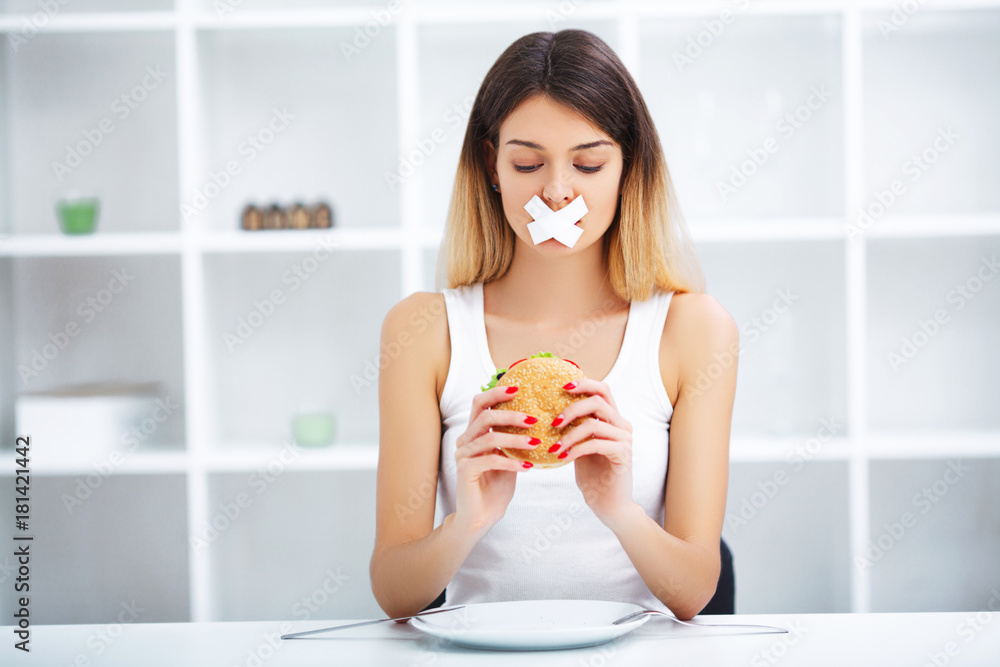 Diet. Young beautiful woman eating burger, It's junk and unhealthy food, Beauty face natural makeup Diet. Young beautiful woman eating burger, It's junk and unhealthy food, Beauty face natural makeup