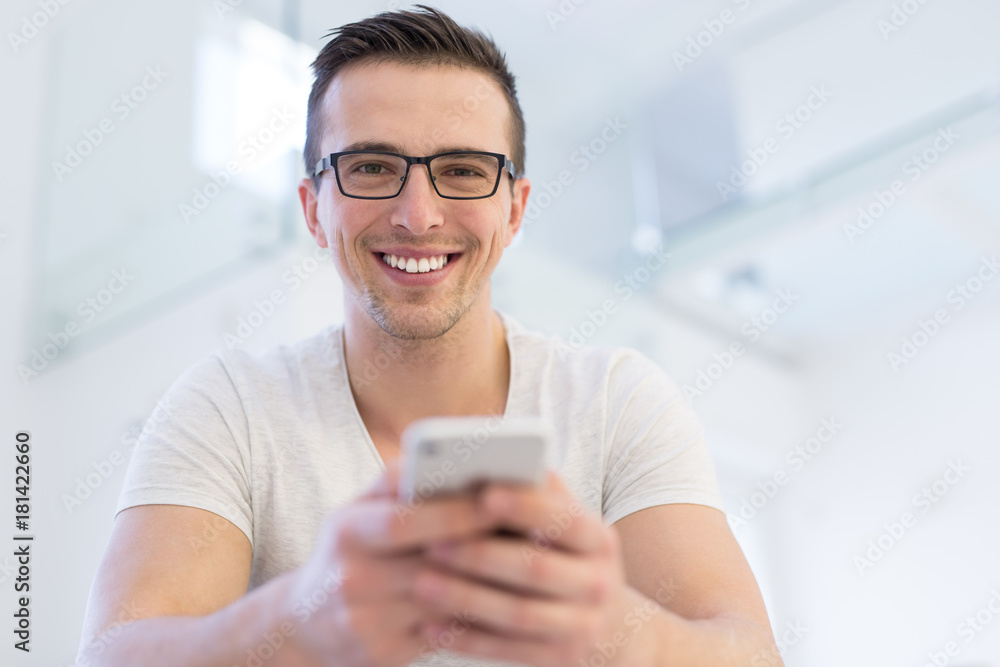 young man using a mobile phone at home young man using a mobile phone at home