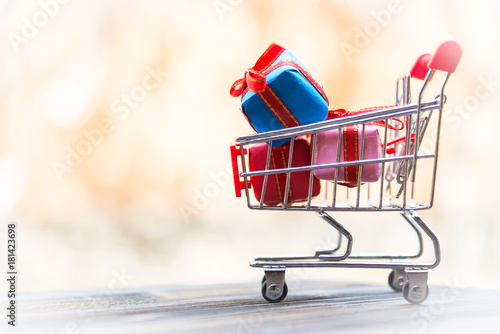 Shopping Christmas and New year   gift box and christmas tree in the shopping cart. Holiday Concept.