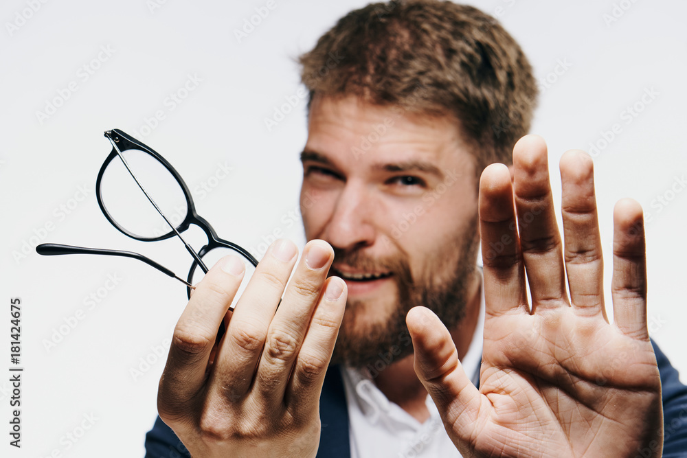 Businessman with a beard on white isolated background holds glasses, portrait Businessman with a beard on white isolated background holds glasses, portrait