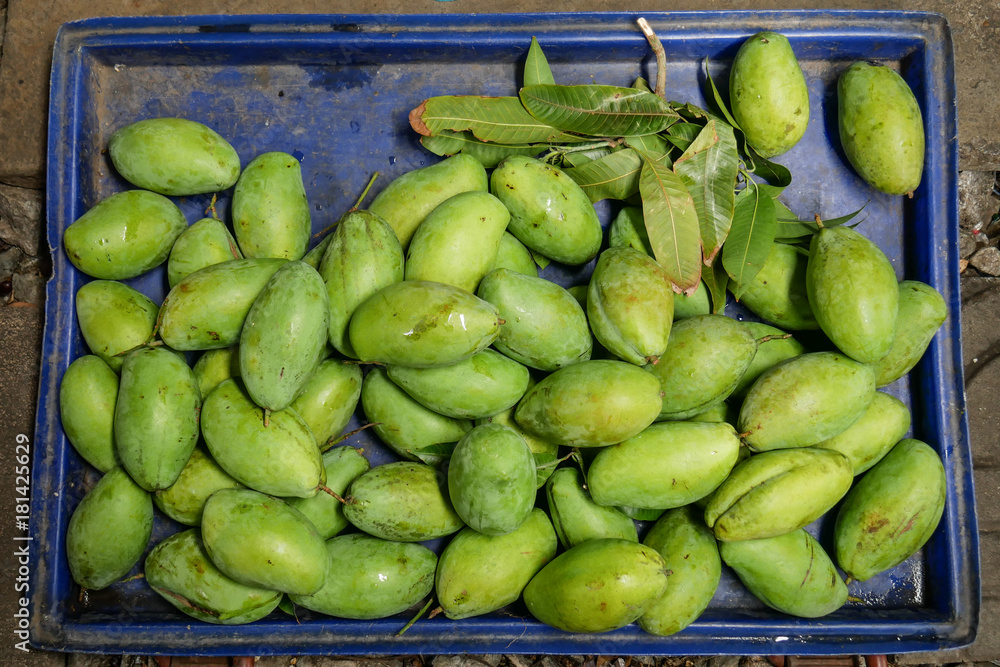 Beautiful composition with green mango in blue tray Beautiful composition with green mango in blue tray