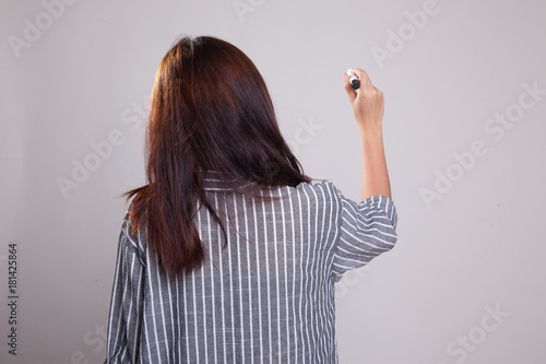 Back of Asian girl write in the air with a marker pen