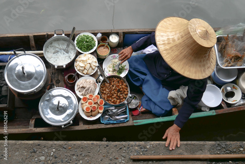 Photography Thai food in floating market, seller with traditional straw hat selling thai foo
