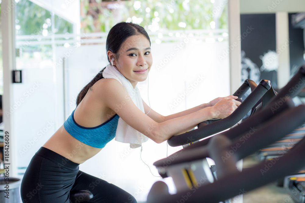 Attractive Asian Woman on exercise bikes at a gym. Woman exercise Concept. Attractive Asian Woman on exercise bikes at a gym. Woman exercise Concept.