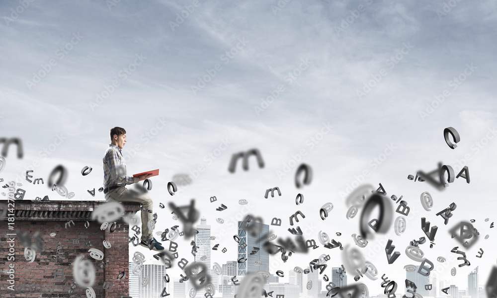 Man on roof edge reading book and symbols flying around Man on roof edge reading book and symbols flying around