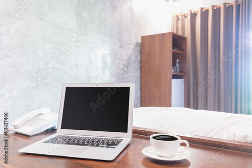 Laptops with white coffee mug on wooden desk
