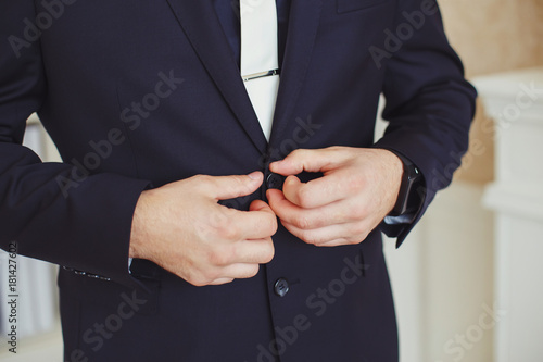 Hands of the groom in dark suit, closeup