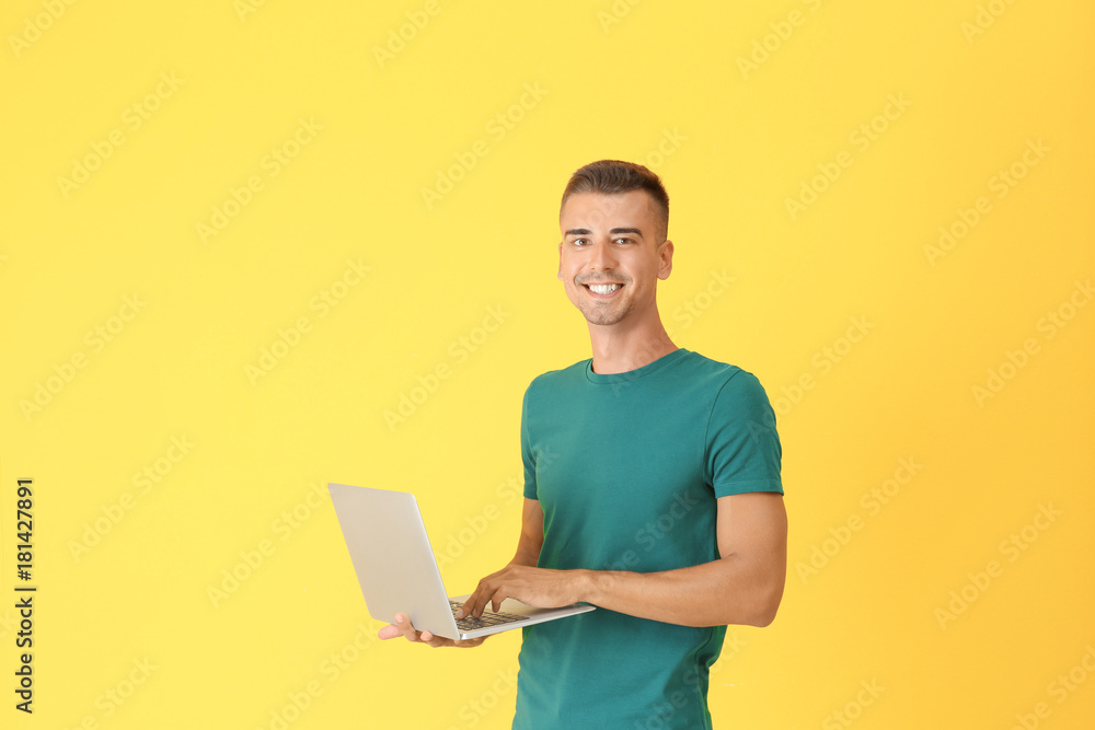 Young man with laptop on color background Young man with laptop on color background