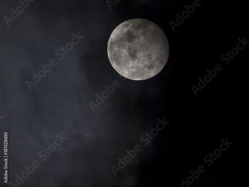 A full moon under heavy cloud in the night sky, Thailand