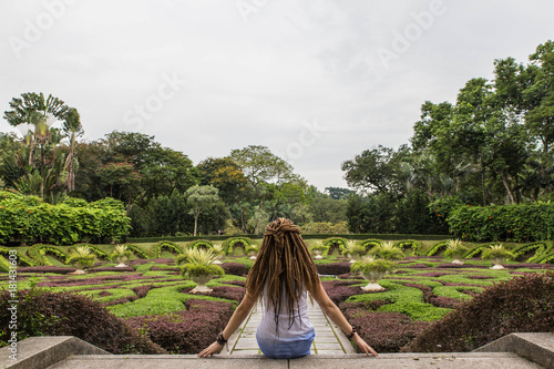 backview of girl, sitting in the botanical garden of Kuala Lumpur in Malaysia