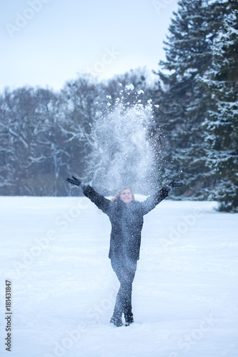 A woman throws up the snow