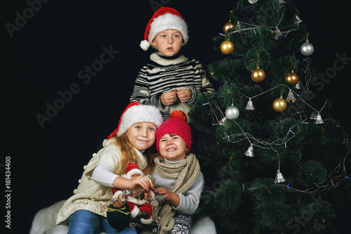 Children decorate the Christmas tree in the room. Merry Christmas and happy holidays