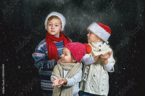 Children playing with snowflakes on a dark background . Merry Christmas and happy holidays