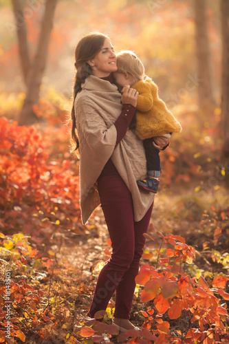 Happy family mother and child daughter playing in nature autumn park on sunset