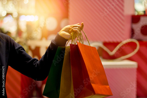 Christmas shopping - shopping bags in hand on the mall departstore background, soft focus photo