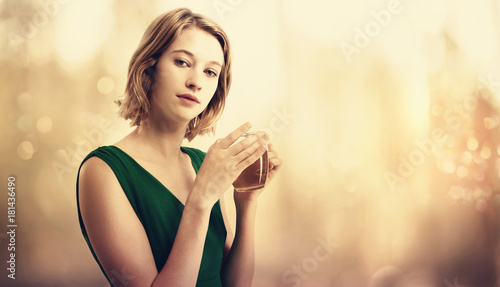 Beautiful young woman in a dress drinking tea