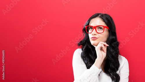 Young businesswoman in a thoughtful pose on a solid background © Tierney