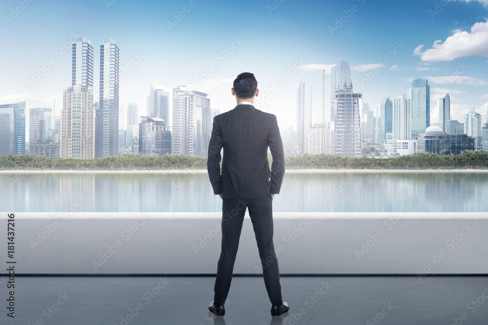 Portrait of asian businessman looking at urban scene Portrait of asian businessman looking at urban scene