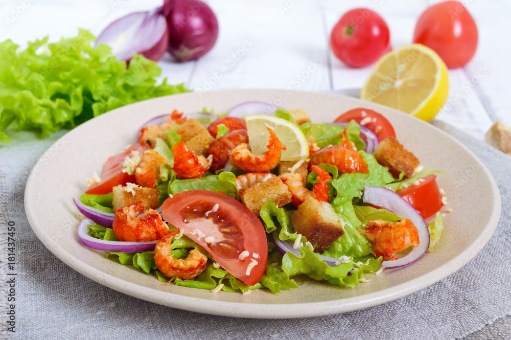Light tasty salad with meat of a cancer, shrimps, lettuce, garlic croutons, tomatoes, red onions on a white background. Light tasty salad with meat of a cancer, shrimps, lettuce, garlic croutons, tomatoes, red onions on a white background.