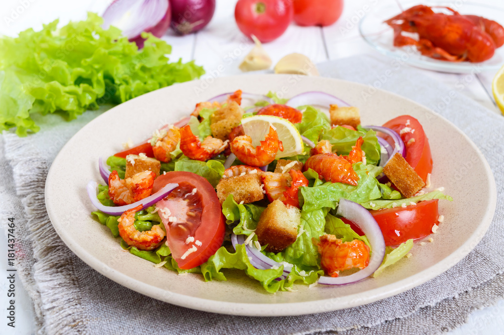 Light tasty salad with meat of a cancer, shrimps, lettuce, garlic croutons, tomatoes, red onions on a white background. Light tasty salad with meat of a cancer, shrimps, lettuce, garlic croutons, tomatoes, red onions on a white background.