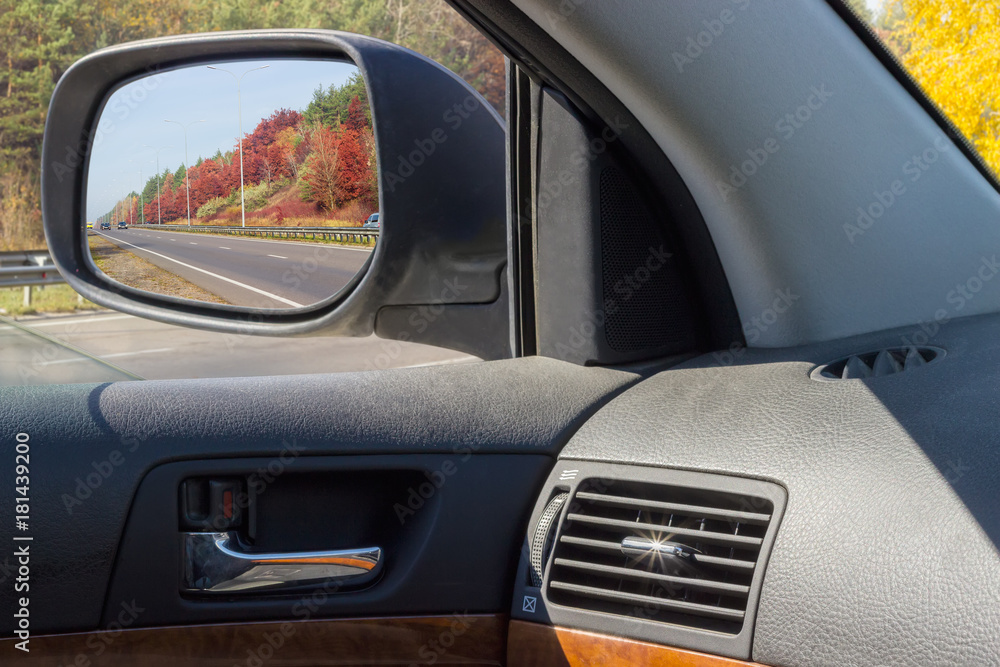 Reflected highway in car side rear-view mirror in autumn Reflected highway in car side rear-view mirror in autumn
