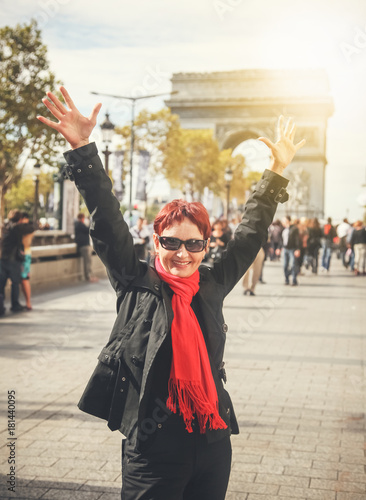 Happy attractive mature woman retired on the Champs Elysees in Paris. Travel, outdoor activities, shopping in Paris