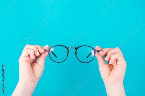 Hands holding glasses on a blue background