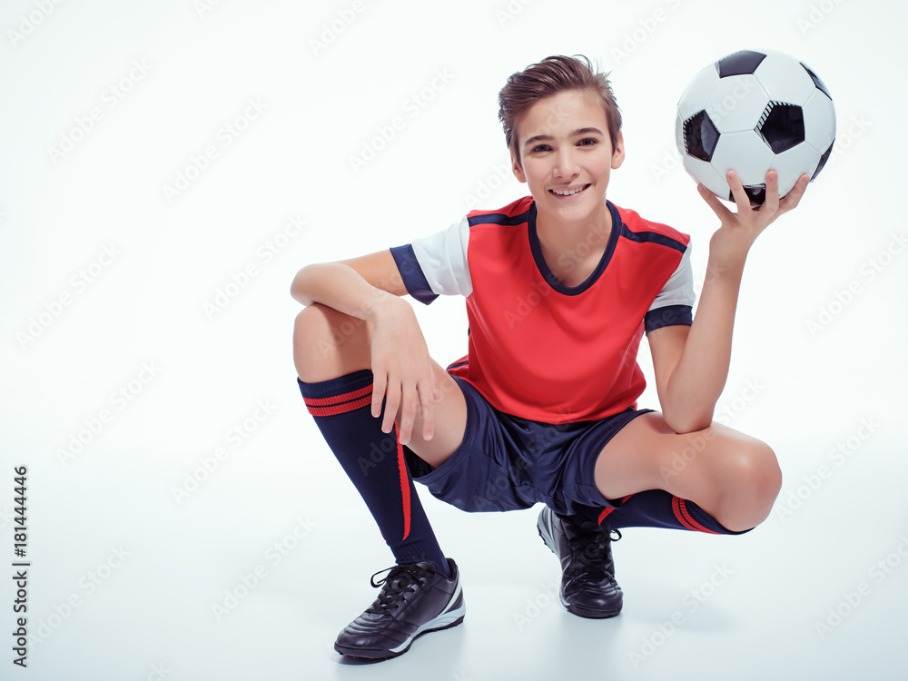 smiling teen boy in sportswear holding soccer ball