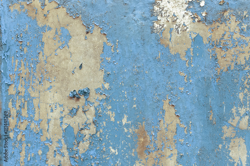 Old grunge and weathered blue wall texture background marked by long exposure to the elements outdoors and painting peeling off.
