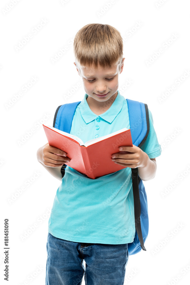 portrait of a boy reading a book, behind his backpack on a white background portrait of a boy reading a book, behind his backpack on a white background