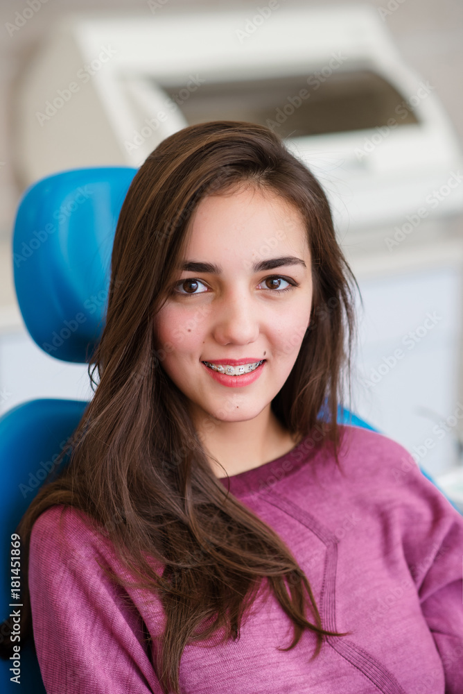 Beautiful girl with dental braces smiles in dentistry. Beautiful girl with dental braces smiles in dentistry.