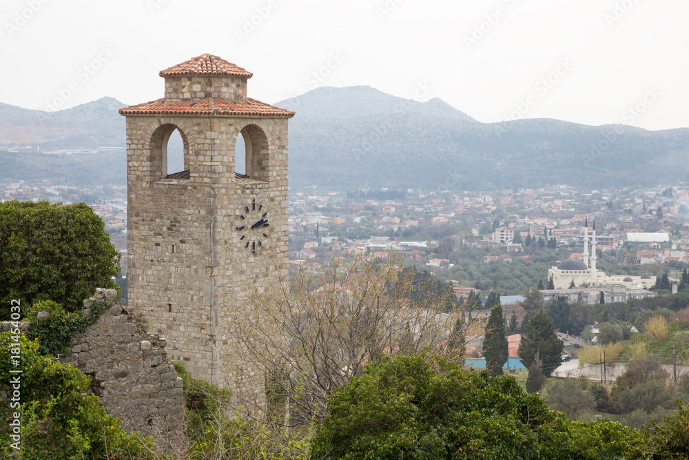 old stone tower with  clock and  panorama of city
