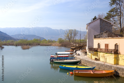 bright boats on lake near  house on background of mountain