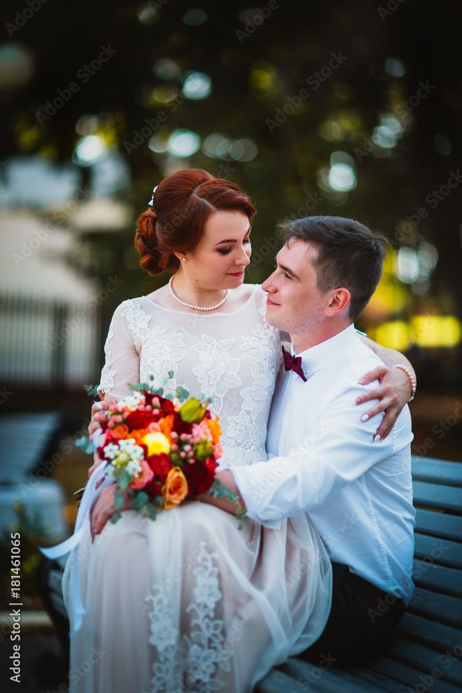 groom and the bride against the trees of the park groom and the bride against the trees of the park