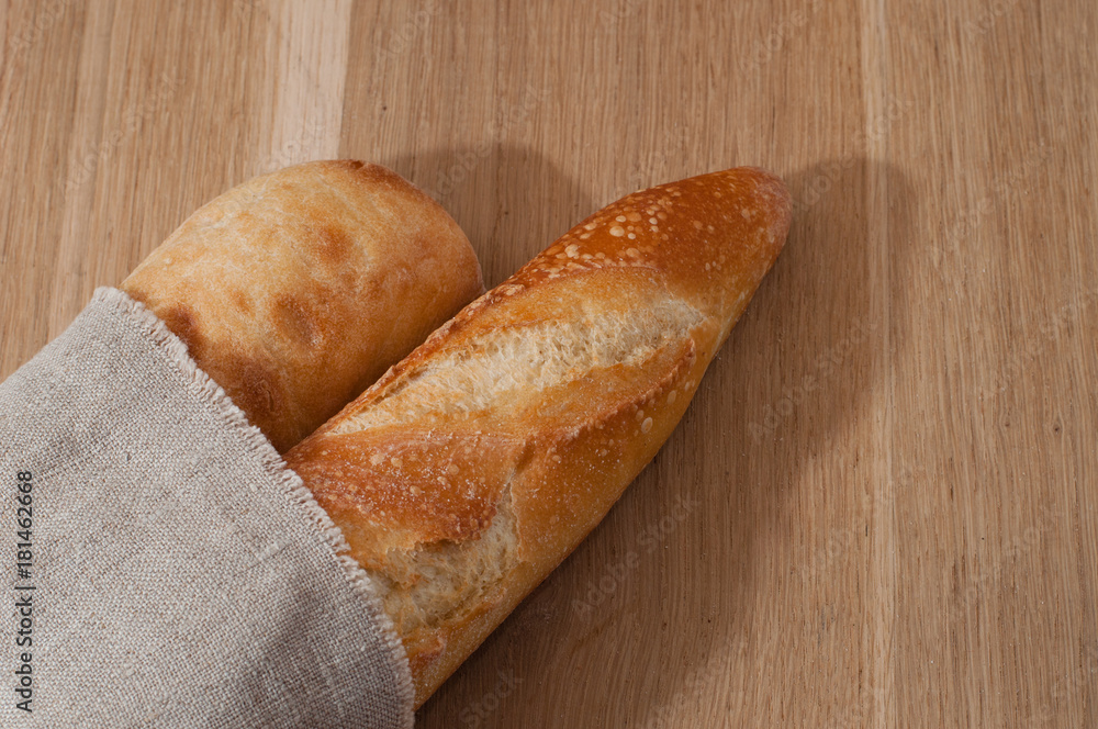 Two baguettes wrapped in a linen napkin Two baguettes wrapped in a linen napkin