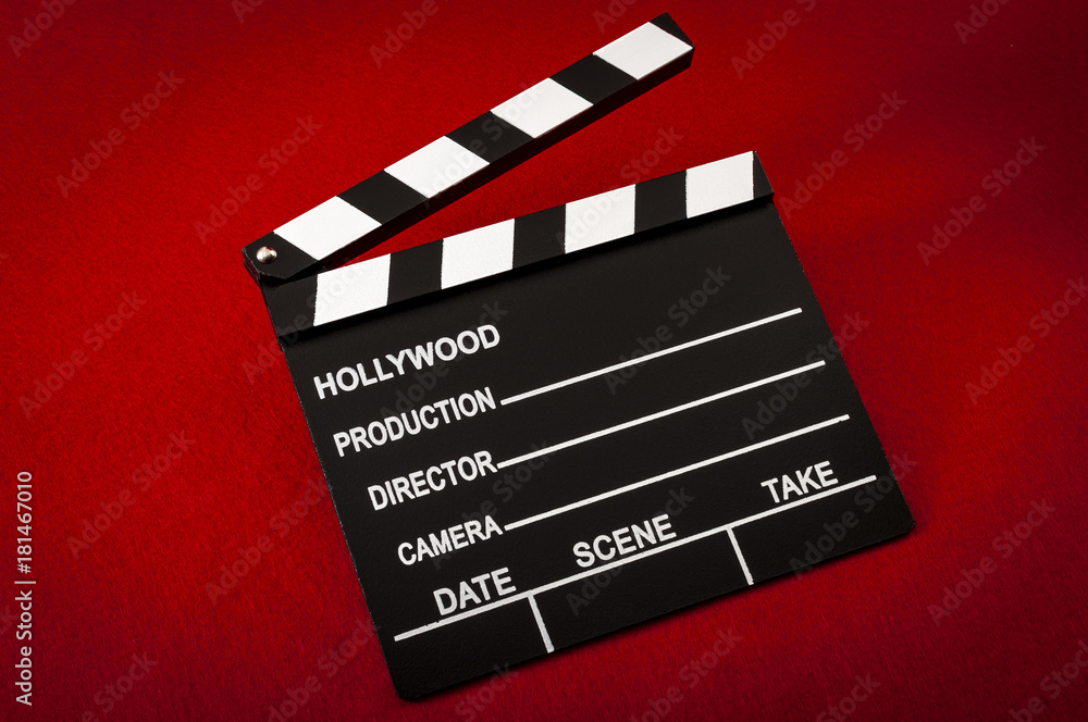 Obraz premium Hollywood and the movie industry concept with a vintage movie clapper board on red background